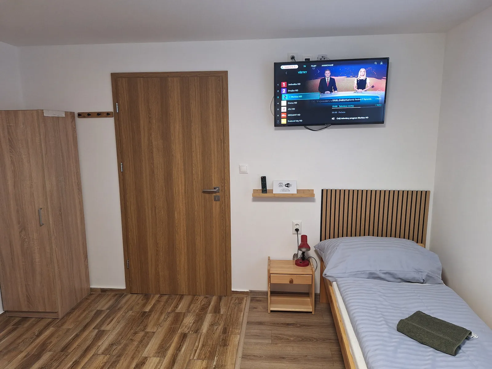 Izba so skriňou, televízorom a posteľou